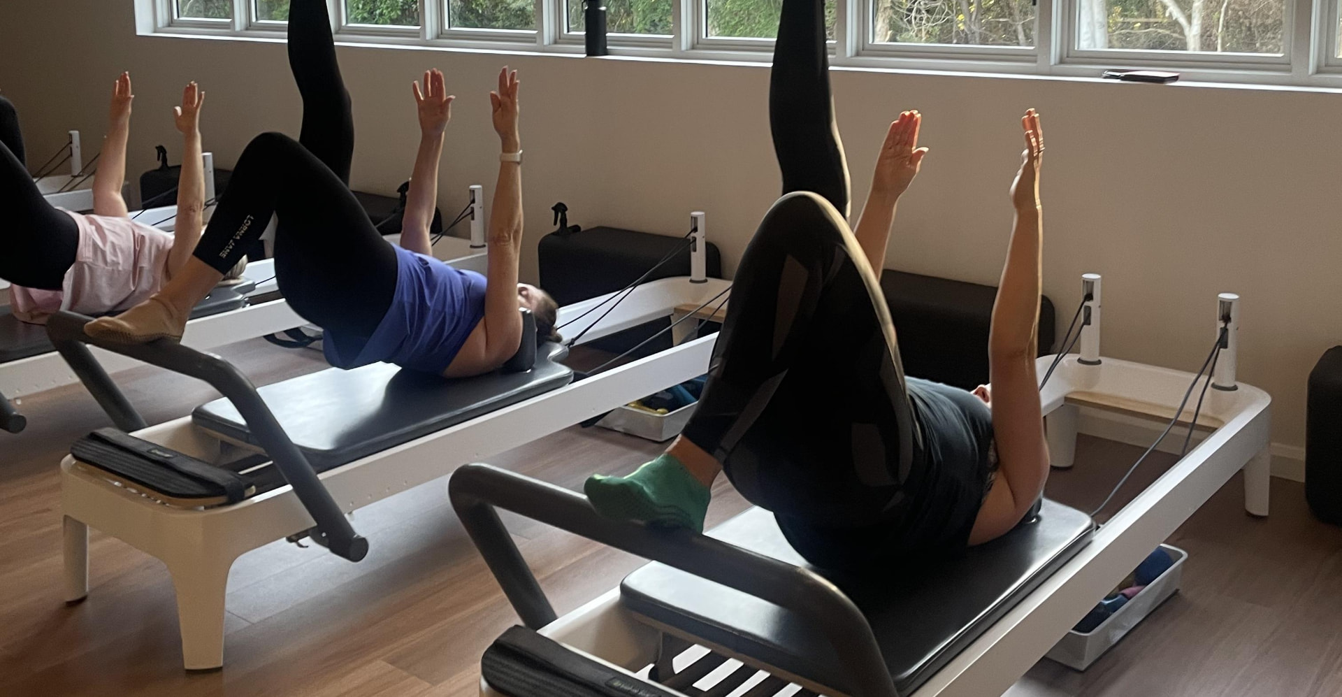 A Reformer class at Ocean Studio Pilates with legs raised overhead